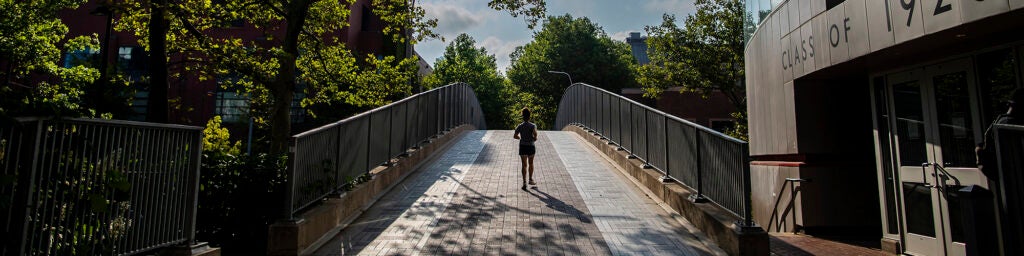 Student walkin gon the birdge by the Class of 29 Commons